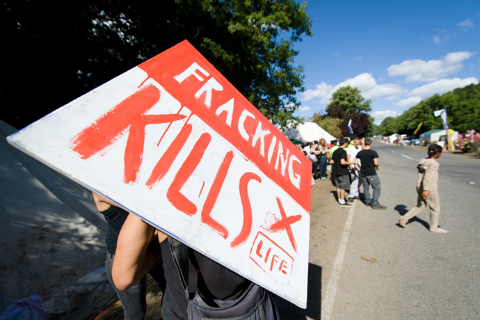 A climate and anti-fracking protester holds a "Fracking kills" placard as he stands outside the test drill site operated by British energy firm Cuadrilla Resources in Balcombe, southern England (AFP Photo / Leon Neal)