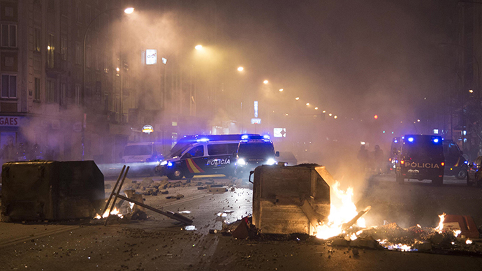 Garbage containers burn near Spanish National Police cars after demonstrators protested against construction plans of turning the main avenue Vitoria into a boulevard, in Burgos January 10, 2014. (Reuters / Ricardo Ordonez)