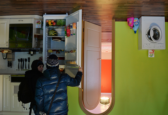 Visitors at the Upside Down House which opened at Moscow's All-Russian Exhibition Center. (RIA Novosti / Valeriy Melnikov)