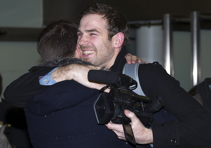 Journalist Kieron Bryan (R), who was detained in Russia with greenpeace activists, embraces his brother Russell at St Pancras International train station in London on December 27, 2013 after arriving back in Britain following an amnesty. (AFP Photo / Justin Tallis)
