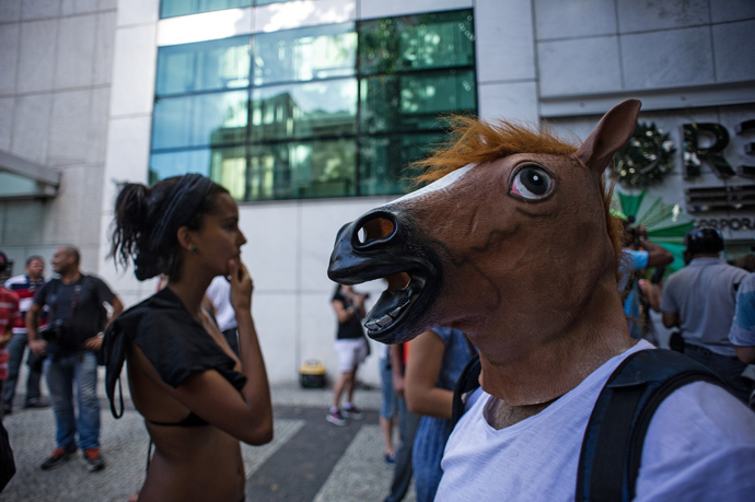 A man wears a horse mask as he waits outside Leblon shopping mall, where a massive gathering called "rolezinho" was called, in Rio de Janeiro, Brazil on January 19, 2014 (AFP Photo / Yasuyshi Chiba)