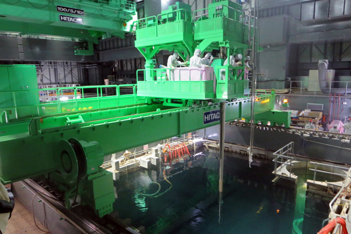 This handout picture taken by Tokyo Electric Power Co. (TEPCO) on November 26, 2013 shows TEPCO workers operating to move a spent fuel rod to a cask, in the storage pool as TEPCO transfers the fuel rods from crippled unit four reactor building to the pool at TEPCO's Fukushima Dai-ichi nuclear plant at Okuma town in Fukushima prefecture. (AFP/TEPCO)