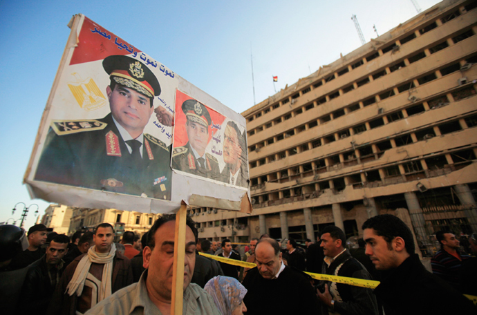 A supporter of Egypt's army chief General Abdel Fatah al-Sisi holds a poster in front of the damaged Cairo Security Directorate building, Cairo, January 24, 2014 (Reuters / Amr Abdallah Dalsh)