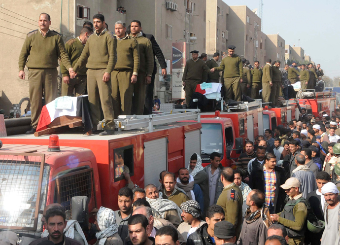 Egyptian police gather around the coffins during the funeral of five Egyptian policemen who were killed when masked gunmen on motorbikes opened fire on a checkpoint in the province of Beni Suef, 100 km (62 miles) south of Cairo, January 23, 2014 (Reuters / Al Youm Al Saabi Newspaper)