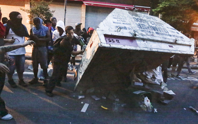Demonstrators put a garbage container upside down during the "Nao Vai Ter Copa" (You are not going to have Cup) protest along Consolacao Street, in Sao Paulo, Brazil, on January 25, 2014. (AFP Photo/Miguel Schincariol)