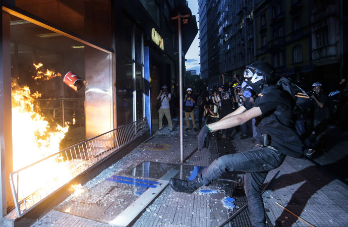 Demonstrators attack a bank branch during the "Nao Vai Ter Copa" (You are not going to have Cup) protest along Consolacao Street, in Sao Paulo, Brazil, on January 25, 2014. (AFP Photo/Miguel Schincariol)
