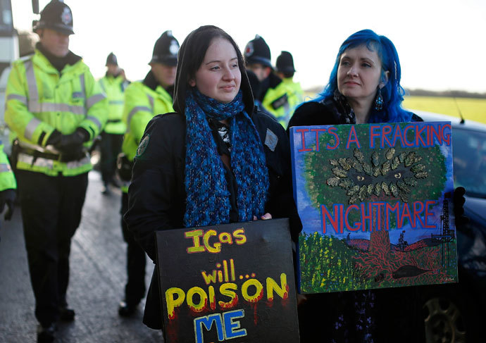 Demonstrators hold placards in front of a police cordon outside the entrance to the IGas Energy exploratory gas drilling site at Barton Moss near Manchester in northern England January 13, 2014. (Reuters / Phil Noble)