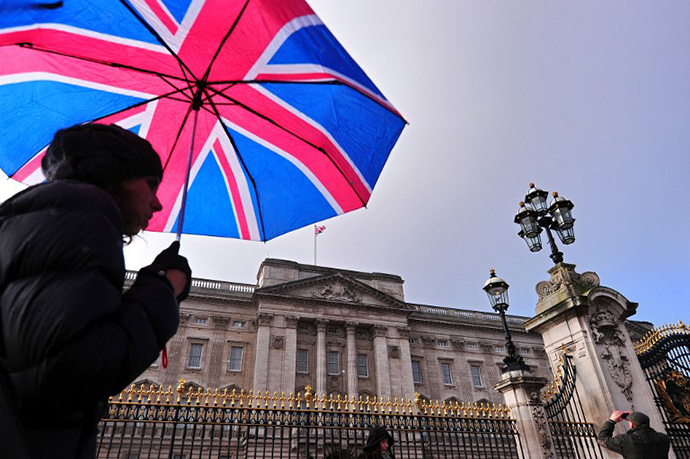 A tourist walks past Buckingham Palace in central London, on January 28, 2014. (AFP Photo / Carl Court)