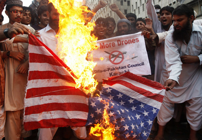 Supporters of the Difa-e-Pakistan Council, an Islamic organization, burn a U.S. flag as they shout slogans during a protest against U.S. drone attacks in the Pakistani tribal region, in Karachi November 8, 2013. (Reuters/Athar Hussain)