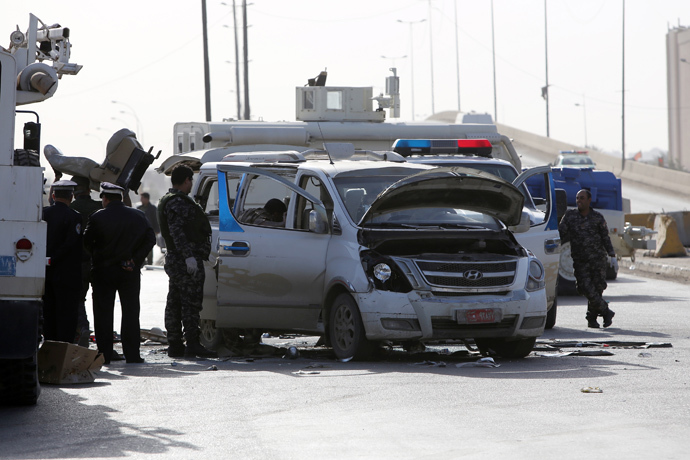 Explosives experts are working to dismantle a car bomb outside a building occupied by a state-owned company that was stormed by attackers on January 30, 2014 in the northeast of the capital Baghdad. (AFP Photo / Ahmad Al-Rubaye)