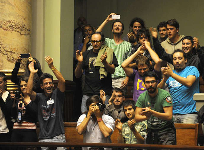 People celebrate after the Uruguayan senate approved a law legalizing marijuana in the Legislative Palace in Montevideo, on December 10, 2013. (AFP Photo / Miguel Rojo)