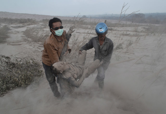 Indonesian residents rescue a victim following eruptions of Mount Sinabung in Karo district, North Sumatra province, on February 1, 2014. (AFP Photo)