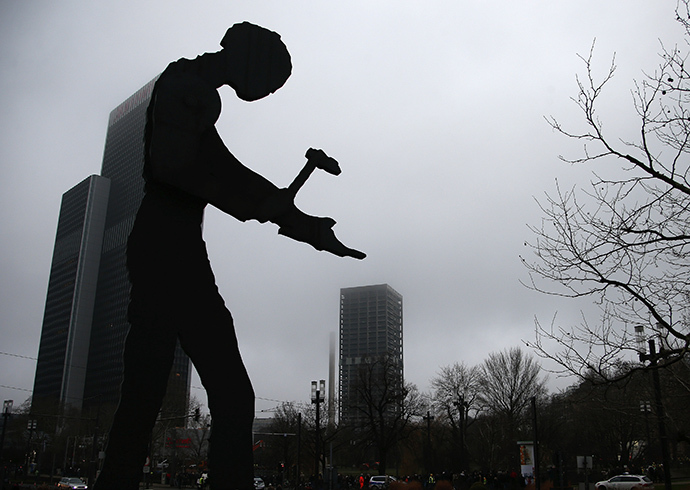 The statue 'Hammering Man' (L) by U.S. artist Jonathan Borofsky near the Fair Tower is pictured next to the AfE tower in Frankfurt February 2, 2014. (Reuters / Ralph Orlowski)