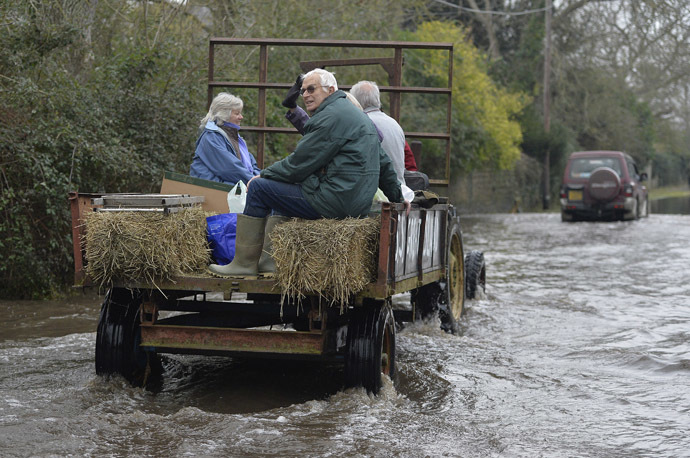 A tractor carries local residents along a flooded road from the village of Thorney on the Somerset Levels, near Langport in south west England January 30, 2014. (Reuters/Toby Melville)