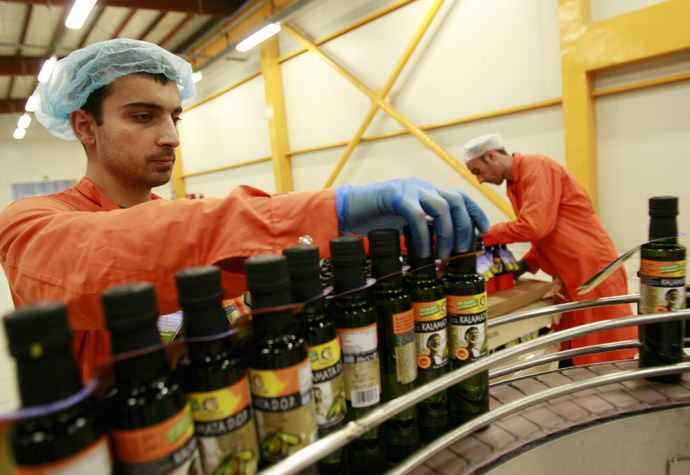 Workers pack bottles of olive oil at the Gaea extra virgin olive oil factory near the town of Agrinio about 350 km northwest of Athens (Reuters/John Kolesidis)