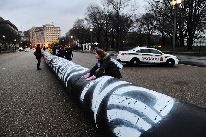 Environmental activists inflate a long balloon to mock a pipeline during a demonstration in front of the White House in Washington, DC, on February 3, 2014 to protest against the Keystone pipeline project. (AFP Photo / Jewel Samad)