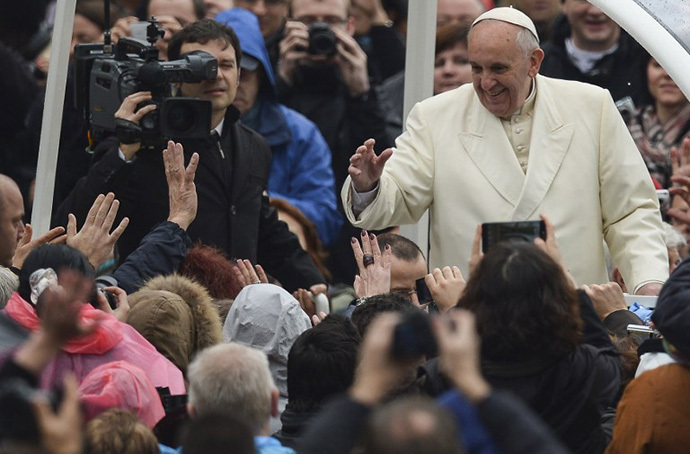 Pope Francis waves to pilgrims gathered at Saint Peter's square in the Vatican, upon his arrival to lead the general weekly audience on February 5, 2014. (AFP Photo / Vincenzo Pinto)
