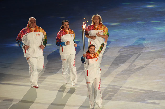 Russian gymnast and Olympian medalist Alina Kabaeva hold up the Olympic torch during the Opening Ceremony of the Sochi Winter Olympics at the Fisht Olympic Stadium on February 7, 2014 in Sochi.(AFP Photo / Damien Meyer)