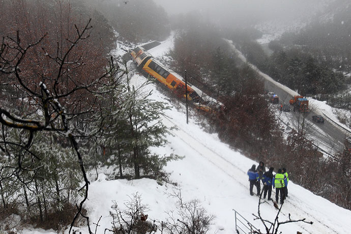 French gendarmes stand near the wreckage of a passenger train near Digne-les-Bains in the French Alps after it derailed on February 8, 2014. (AFP Photo / Jean-Christophe Magnenet)