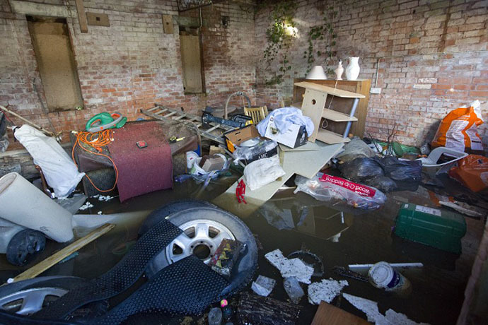 Belongings are seen, piled up in a outhouse which has been surrounded by flood water in Moorland, 19 Kms northeast of Taunton on February 7, 2014. (AFP Photo / Justin Tallis)