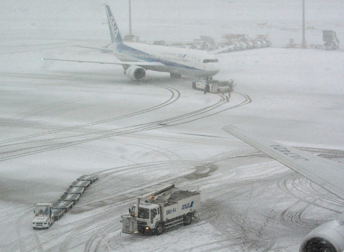 A jetliner of Japan's All Nippon Airways (ANA) taxis at Tokyo's Haneda airport covered by the snow on February 8, 2014 (AFP Photo / Kazuhiro Nogi)