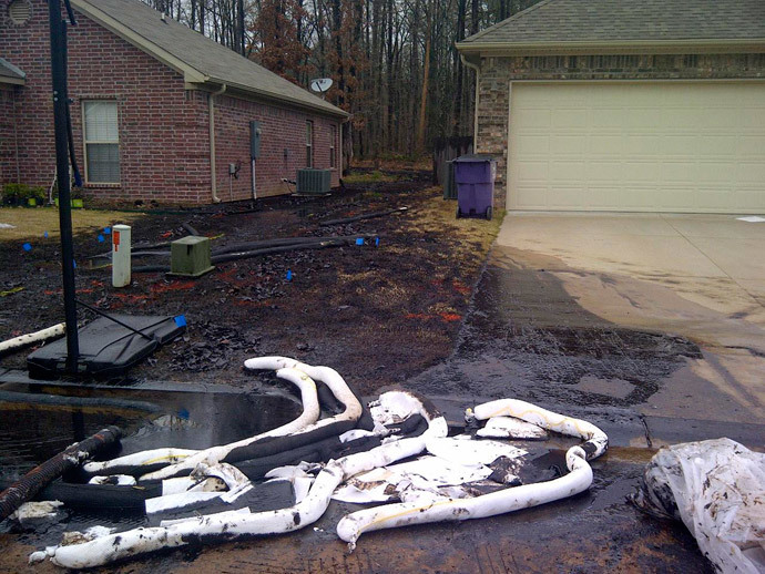 Spilt oil from Exxon pipeline runs between homes in North Woods Subdivision in Mayflower, Arkansas in this March 31, 2013 photo released to Reuters on April 11, 2013.(Reuters /Handout)