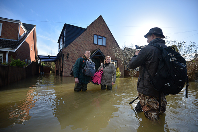 Residents speak to a TV journalist in a flooded street in the village of Wraysbury in Berkshire, South East England, on February 10, 2014. (AFP Photo / Ben Stansall)