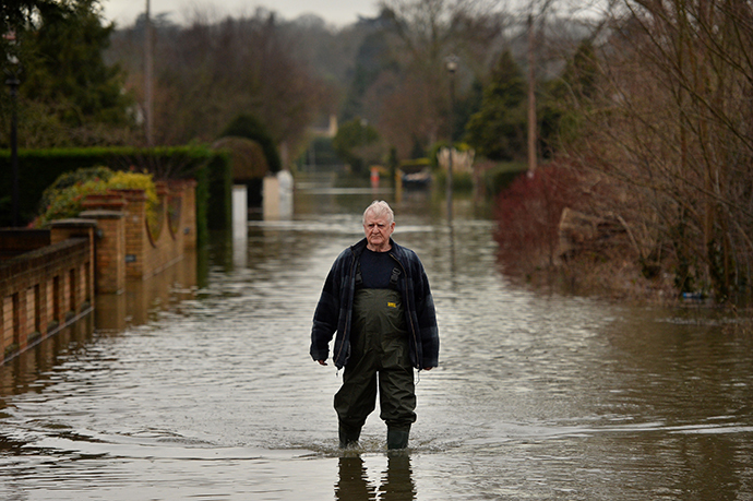 A resident walks through flood water in Wraysbury, Berkshire, on February 10, 2014. (AFP Photo / Ben Stansall)