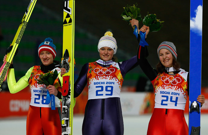First placed Germany's Carina Vogt (C), second placed Austria's Daniela Iraschko-Stolz (L) and third placed France's Coline Mattel pose during the flower ceremony of the women's ski jumping individual normal hill event at the Sochi 2014 Winter Olympic Games, at the RusSki Gorki Jumping Centre, in Rosa Khutor February 11, 2014 (Reuters / Michael Dalder)