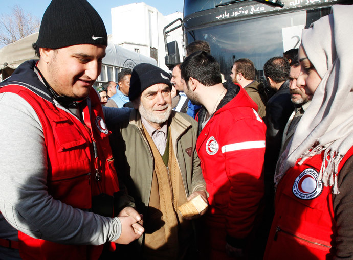 Members of the Syrian Arab Red Crescent assist a man evacuated from a besieged area of Homs, after his arrival to the area under government control February 7, 2014.(Reuters / Khaled al-Hariri )