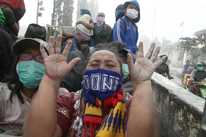 A woman gestures during the evacuation in Malang, East Java province, on February 14, 2014 moment after Mount Kelud eruption. (AFP Photo / Aman Rochman)