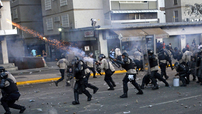 A riot policeman shoots tear gas during clashes with anti-government students holding a protest, in Caracas on February 15, 2014.( AFP Photo / Leo Ramirez )