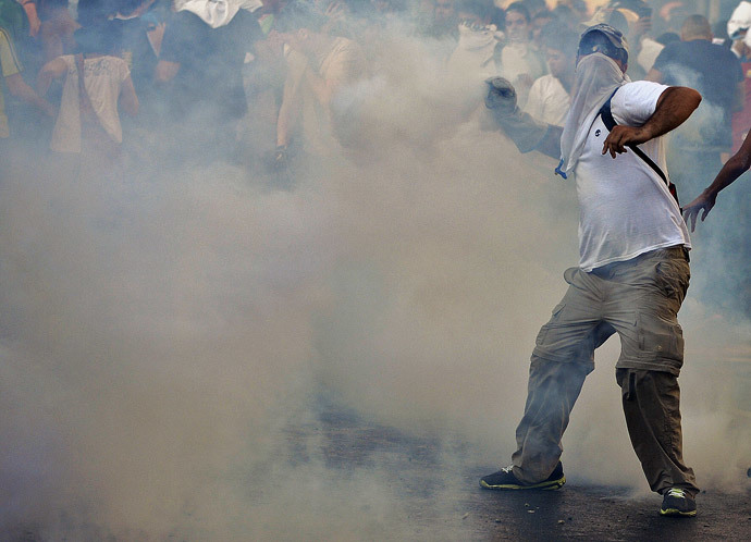  Anti-government students throw stones to riot police during a protest, in Caracas on February 15, 2014. ( AFP Photo / Juan Barreto )