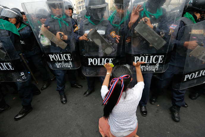 An anti-government protester pushes a line of policemen during clashes near the Government House in Bangkok February18, 2014.(Reuters / Damir Sagolj)