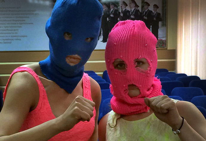 Wearing masks members of Russian punk group Pussy Riot, Nadezhda Tolokonnikova (L) and Maria Alyokhina (R), pose for a photo in a police station after their arrest in the Adler district of Sochi, on February 18, 2014.(AFP Photo / Evgeny Feldman) 