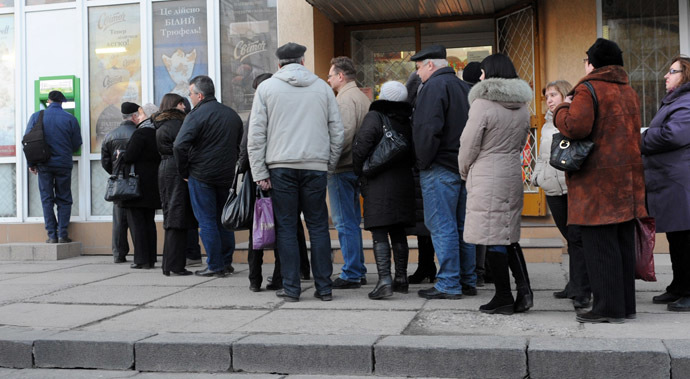 People stand in a queue to get their money from bank machine in the western Ukrainian city of Lviv on February 20, 2014, as a result of the financial panic caused with clashes between anti-government opposition and police in Kiev. (AFP Photo)