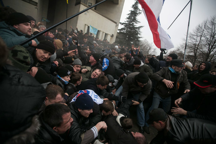 Ukrainian men help pull one another out of a stampede as a flag of Crimea is seen during clashes at rallies held by ethnic Russians and Crimean Tatars near the Crimean parliament building in Simferopol February 26, 2014. (Reuters / Baz Ratner)
