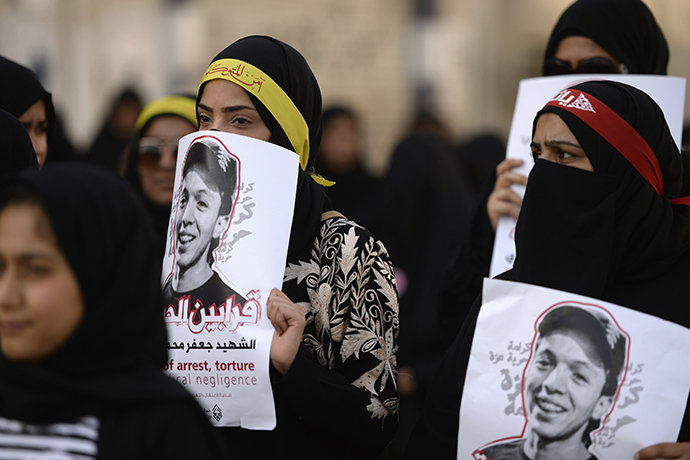 Protesters hold pictures of detainee Jaffar Mohammed Jaffar during a protest over his death at a hospital, ahead of his funeral in the village of Daih, west of Manama, February 27, 2014. (Reuters)