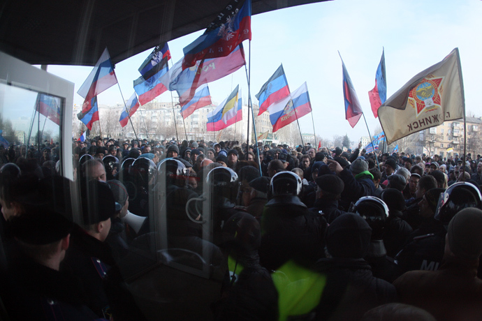 A line of police stand guard as pro-Russian protesters wave Russian flags during a rally in front of the regional administration building in the industrial Ukrainian city of Donetsk on March 1, 2014 (AFP Photo / Alexander Khudoteply)