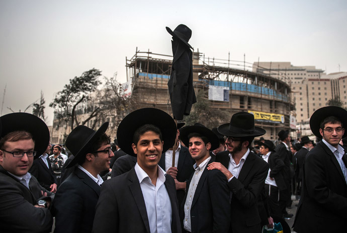 Ultra-Orthodox Jews hold a coat and a hat on a stick as they take part in a mass prayer vigil in Jerusalem on March 2, 2014 .(AFP Photo / David Buimovitch)