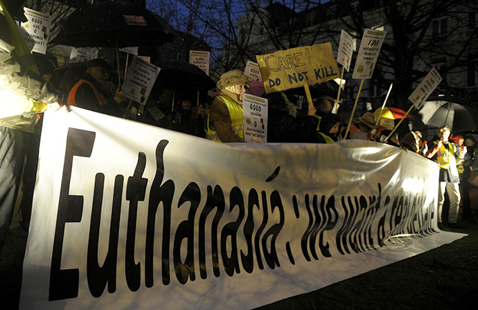 Protesters, who call themselves the "yellow jackets", hold banners and placards as they demonstrate against a new law authorizing euthanasia for children, in Brussels February 11, 2014. (Reuters / Laurent Dubrule)
