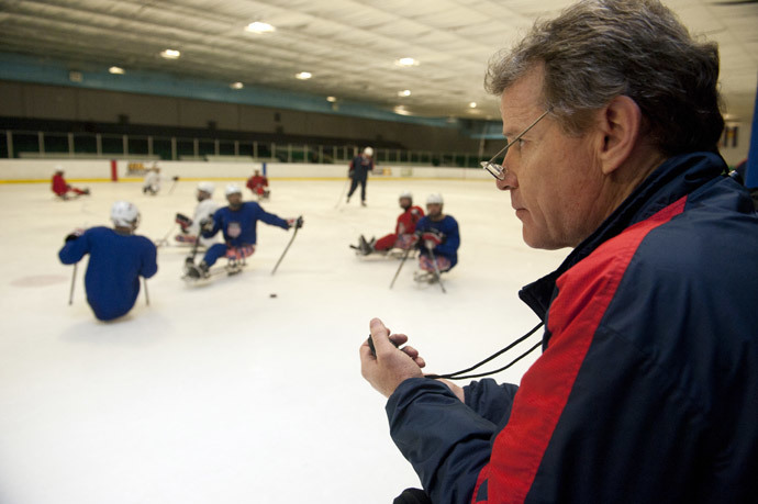 U.S. Paralympic Sled Hockey Team Athletic Trainer Mike Cortese watches his stop watch as the team practices speed drills during the team's last U.S. based practice at the Sertich Ice Arena in Colorado Springs, Colorado on February 27, 2014.(AFP Photo / Jason Connolly)