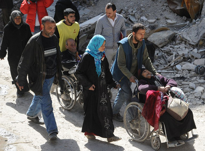 A handout picture released by the official Syrian Arab News Agency (SANA) on February 24, 2014 shows residents of Syria's besieged Yarmuk Palestinian refugee camp, south of Damascus, being evacuated during an operation led by the UN agency for Palestinian refugees UNRWA. (AFP Photo / SANA)