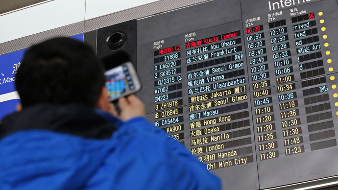 A man takes pictures of a flight information board displaying the Scheduled Time of Arrival (STA) of Malaysia Airlines flight MH370 (top, in red) at the Beijing Capital International Airport in Beijing, March 8, 2014.(Reuters / Kim Kyung-Hoon)