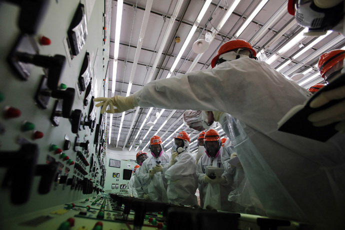 Members of the media and Tokyo Electric Power Co. (TEPCO) employees wearing protective suits and masks visit the central control room for the No. 1 and No. 2 reactors at the tsunami-crippled TEPCO's Fukushima Daiichi nuclear power plant in Fukushima prefecture March 10, 2014. (Reuters / Toru Hanai) 