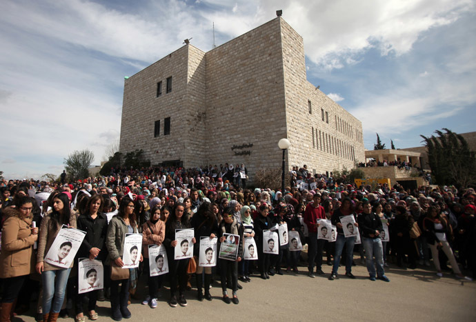 Palestinian students from the Bir zeit University attend the funeral procession of their comrade Saji Sayel Darwish (portraits) who was killed the previous day by Israeli soldiers, on March 11, 2014 in the northern West Bank town of Bir Zeit. (AFP Photo/Abbas Momani)