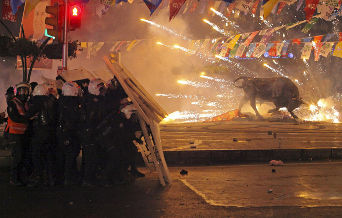 Riot policemen shield themselves as fireworks thrown by protesters explode next to the statue of a bull, during an anti-government protest in the Kadikoy district of Istanbul March 11, 2014. (Reuters)