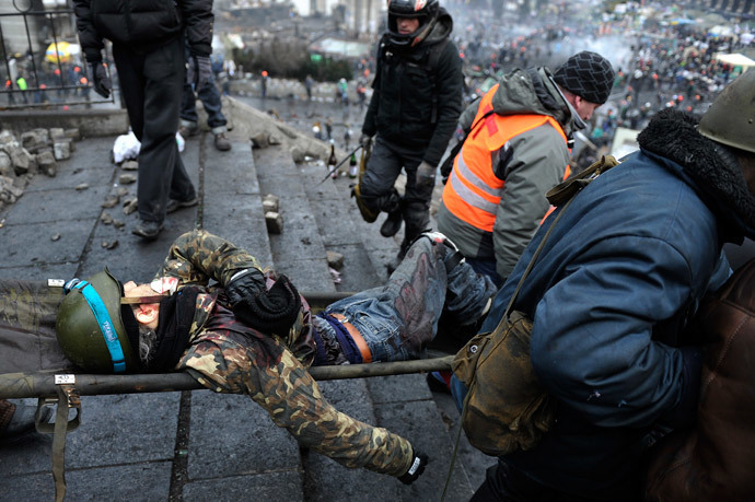 Protesters evacuate a wounded demonstrator from Independence square, dubbed Maidan, in Kiev on February 20, 2014. (AFP Photo / Louisa Gouliamaki)