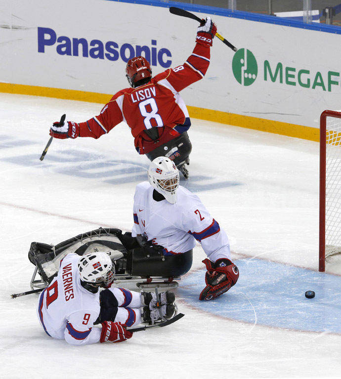 Russia's Dmitrii Lisov scores against Norway's Morten Vaernes (L) and Kristian Buen (C) during the semi-final sledge hockey game at the 2014 Sochi Winter Paralympic Games March 13, 2014. (Reuters)
