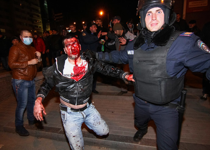 A police officer escorts a wounded participant of an anti-war rally during clashes with pro-Russian demonstrators in Donetsk March 13, 2014. (Reuters / Stringer)